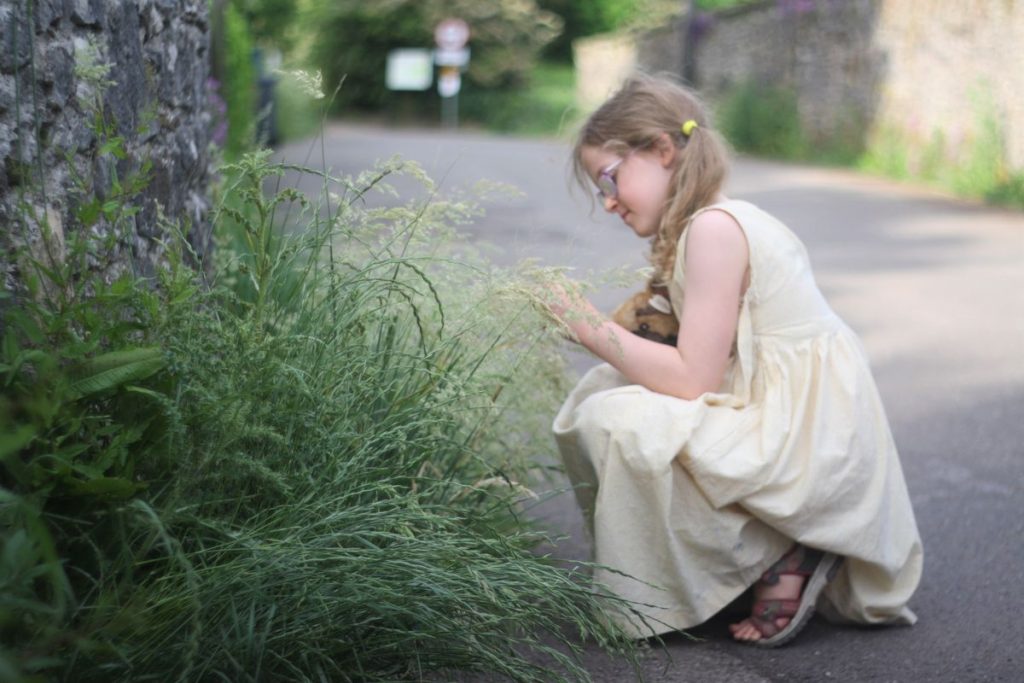 girl picking wild grasses to make dried grasses