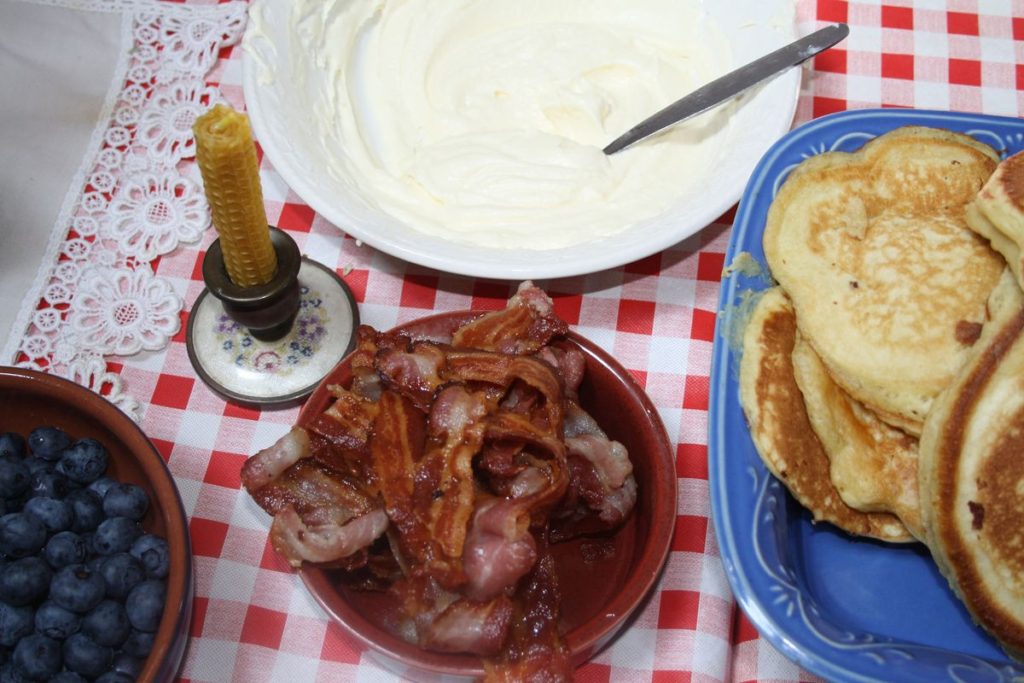 bacon, blueberries, and pancakes for a family meal.