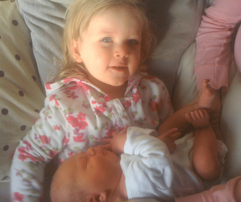 Big sister holding her new baby brother