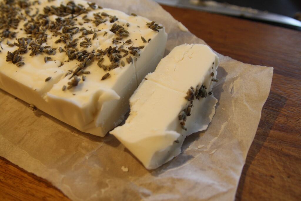 a block of lavendar scented homemade soap being sliced