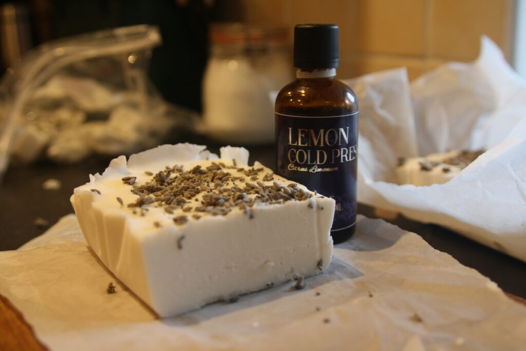 block of simple homemade soap with essential oils bottle